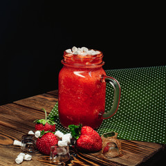 Strawberry lemonade in a glass on a wooden background