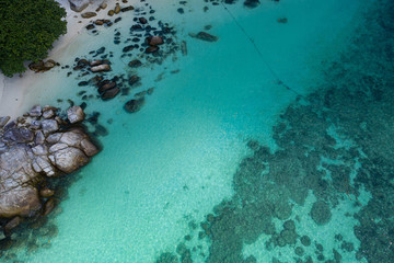 Aerial drone view of beautiful tropical beach with white sand and crystal clear lagoon sea water