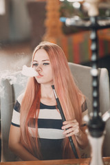Obraz na płótnie Canvas Young beautiful female smoking hookah. Smoke shisha hookah concept.