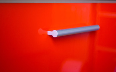 red kitchen facade with aluminum handle, close up