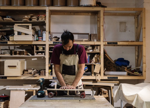 Artisan assembling skateboard in shop