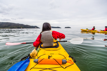 Friends ocean kayaking together in New Zealand