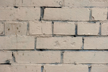 Old painted beige color weathered stained brick wall