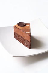 Vegan Dark Chocolate Brownie Cake with Chocolate Truffle Mousse, on white background.