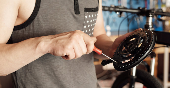 Mechanic Repairing Bike Chainwheel