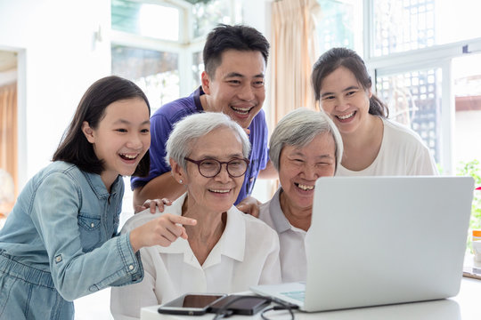 Family Asian Man And Elderly People ,watching Something Interesting With Grandmother,happy Smiling Senior Woman And Family Using Laptop Computer In Home,technology,family,generation Concept