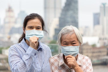 Asian mother and daughter  with face mask protection;senior people wearing face mask because of air pollution in the city;elderly woman with medical mask;concept of pollution dust, allergies 
