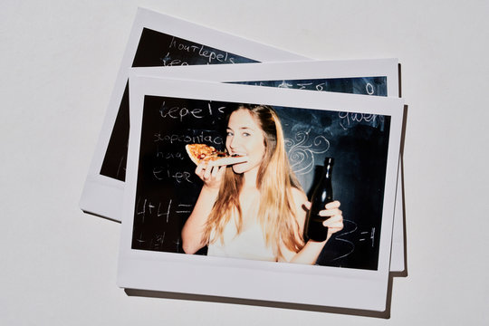 Pretty girl biting pizza and drinking beer.