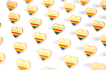 Blurry closeup shot on golden heart with rainbow and word PRIDE inside pattern. June as month of pride concept. Isolated on white background. 3D rendering