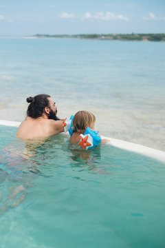 Father With Little Son Relaxing In A Pool
