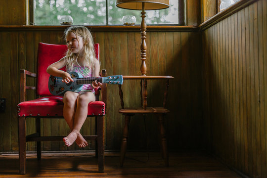 Young Girl Seated with Guitar