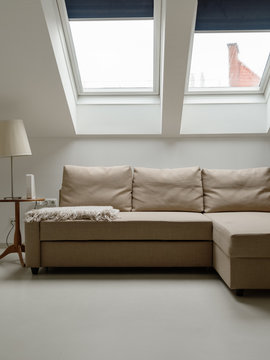 Cozy beige couch under mansard windows