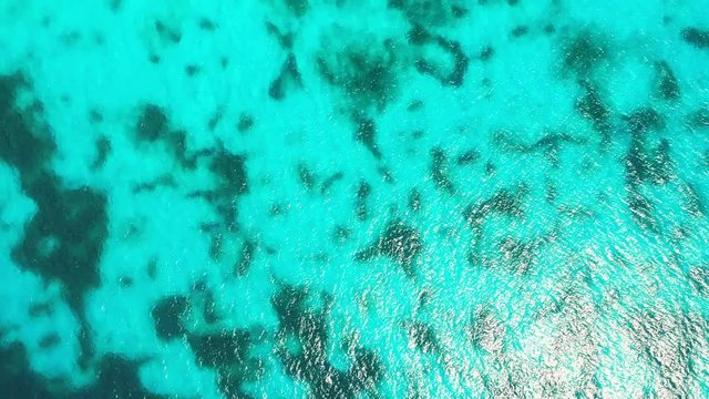 Aerial top view of ripple turquoise caribbean sea and coral reef as background