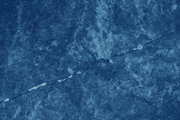 Vintage blue background. Rough painted wall of sapphire color. Imperfect plane of blue colored. Uneven old decorative toned backdrop of cyan tint. Texture of sapphirine hue. Ornamental stony surface.