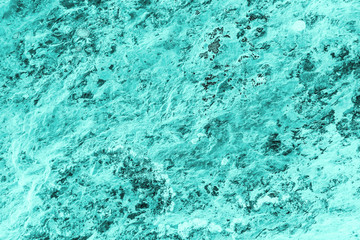 Vintage azure background. Rough painted wall of turquoise color. Imperfect plane of cyan colored. Uneven old decorative toned backdrop of aqzure tint. Texture of teal hue. Ornamental stony surface.