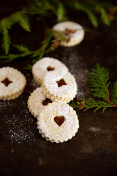 Apricot jam cookies on dark wood with pine twigs