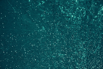 Vintage azure background. Rough painted wall of turquoise color. Imperfect plane of cyan colored. Uneven old decorative toned backdrop of aqzure tint. Texture of teal hue. Ornamental stony surface.
