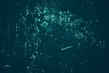 Vintage azure background. Rough painted wall of turquoise color. Imperfect plane of cyan colored. Uneven old decorative toned backdrop of aqzure tint. Texture of teal hue. Ornamental stony surface.