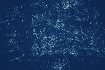 Vintage blue background. Rough painted wall of sapphire color. Imperfect plane of blue colored. Uneven old decorative toned backdrop of cyan tint. Texture of sapphirine hue. Ornamental stony surface.