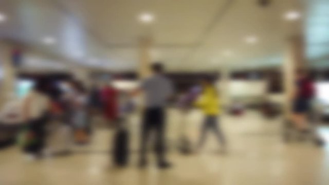 Blurred, defocused footage of suitcase, luggage with conveyor belt and passengers waiting in the airport. Blurry, defocus background people wheeled suitcase on a luggage belt at the airport terminal