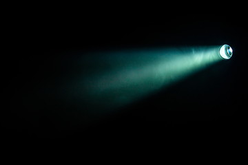 projector spotlight green color on smoke texture background . light beam screening and glowing for movie cinema and film multimedia production in dark black room at night . with copy space for text .