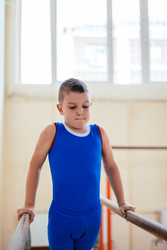 Gymnastics, young boy practicing on parallel bars