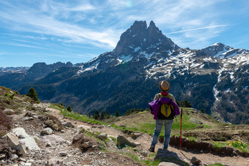 Fototapeta premium hiker woman walking in the french Pyrenees mountains, Pic du midi d Ossau in background