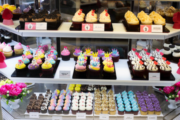 Many Good Looking design and colorful Bakery Cake in refrigerator windows show, present variety of Price and vanilla chocolate birthday cake for special occasion, blur by frozen ice glass