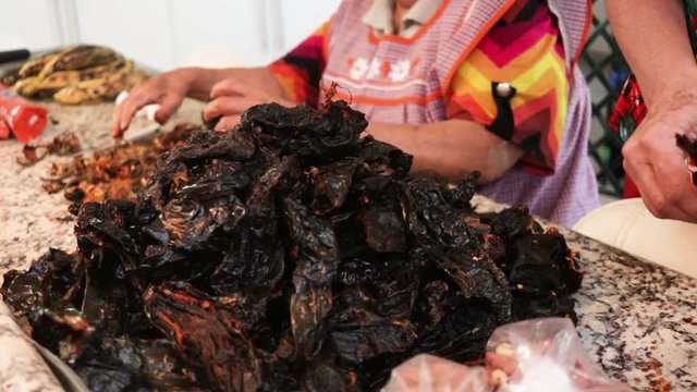 Side View. Women cleaning and removing seeds from chile. Women making Mole in Puebla Mexico. North America.  Cooking Traditional recipe