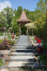 Escalier montant vers une pagode dans un parc floral