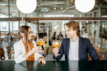 Business partners having unofficial meeting, drinking together some cocktails at the bar
