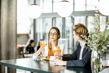 Business partners having unofficial meeting, drinking together some cocktails at the bar