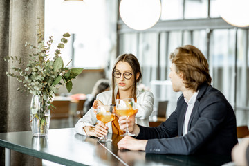 Business partners having unofficial meeting, drinking together some cocktails at the bar