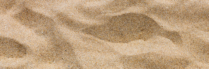 Sand surface and background. Sand Texture. Brown sand. Background from fine sand. Sand background. Closeup of sand pattern of a beach in the summer.