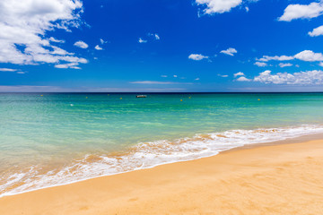Obraz premium Blue ocean wave on sandy beach. Soft wave of blue ocean on sandy beach. Background. Top view of Beautiful beach with tranquil wave, sea and ocean background, summer vacation concept.