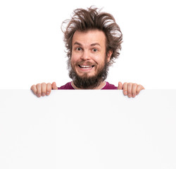 Crazy bearded Man with funny Haircut showing empty blank signboard with copy space. Smiling guy...