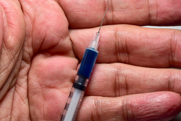 Syringe in the palm of the hand