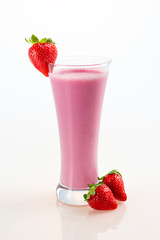 Glass of strawberry milkshake on white background