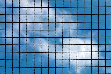 Lattice fence on the background blue sky.
