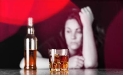 Young beautiful woman in depression, is drinking