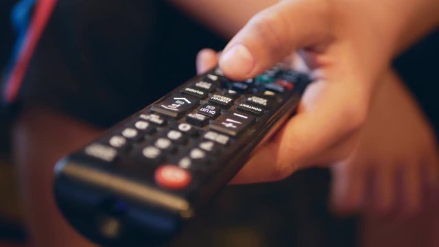 TV remote control close-up. Change channels on the TV remote. Hand using tv remote control