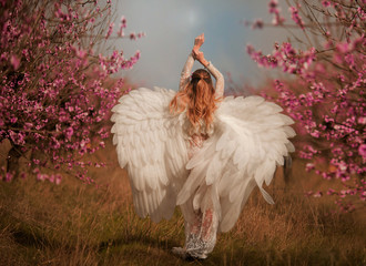 Beautiful yound woman with giant white angel wings