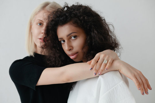 Portrait of two fashionable women in white studio