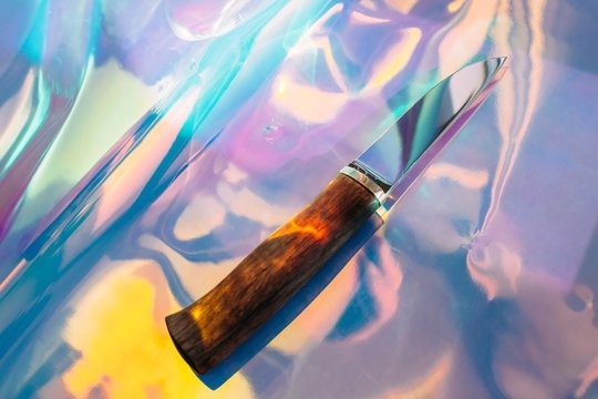Stylish knife on colorful holographic background