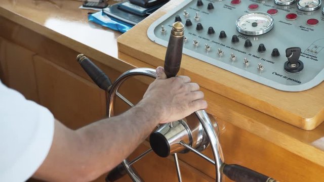 Detail of Man's hand at the wheel rudder boat
