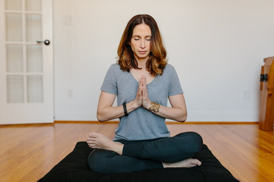 Beautiful woman practicing meditation at home