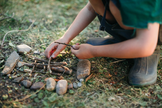 Little boy building a tiny campfire