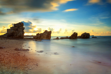 seascape with natural stone arch at sunrise