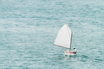 Boy in an optimist dinghy in English Harbour in Antigua