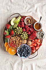 Healthy breakfast board included granola, fruits and berries selection, nuts and honey. Plant based, clean eating, super food, vegetarian concepts.